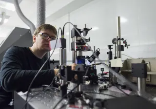 Photo of VTT MIKES researcher using measurement equipment